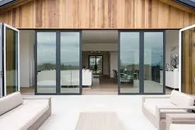 Dark aluminium sliding door set into a timber-clad wall of a modern villa
