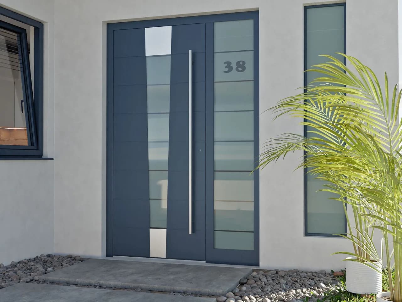 Dark grey aluminium entrance door with vertical glass slot and house number